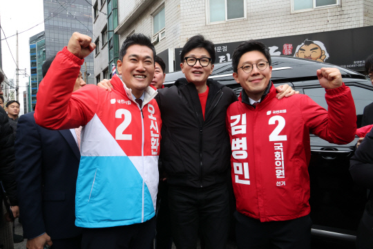 한동훈(가운데) 국민의힘 비상대책위원장이 20일 오후 서울 광진구 화양동에서 '시민이 안전한 대한민국' 현장 공약 발표를 하기 위해 이동하기 전 단수공천을 받은 오신환(왼쪽) 광진을 후보, 김병민(오른쪽) 광진 갑 후보와 기념 촬영하고 있다.<연합뉴스 사진>